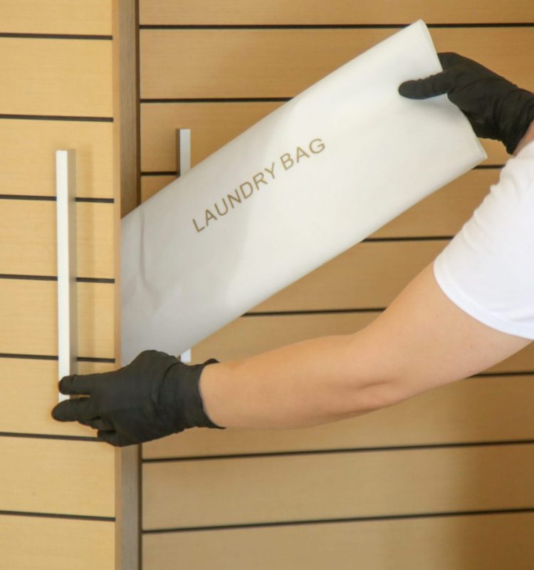 Hospitality & hotel laundry service, Room staff bringling laundry bag and clean clothes in the hotel apartment.